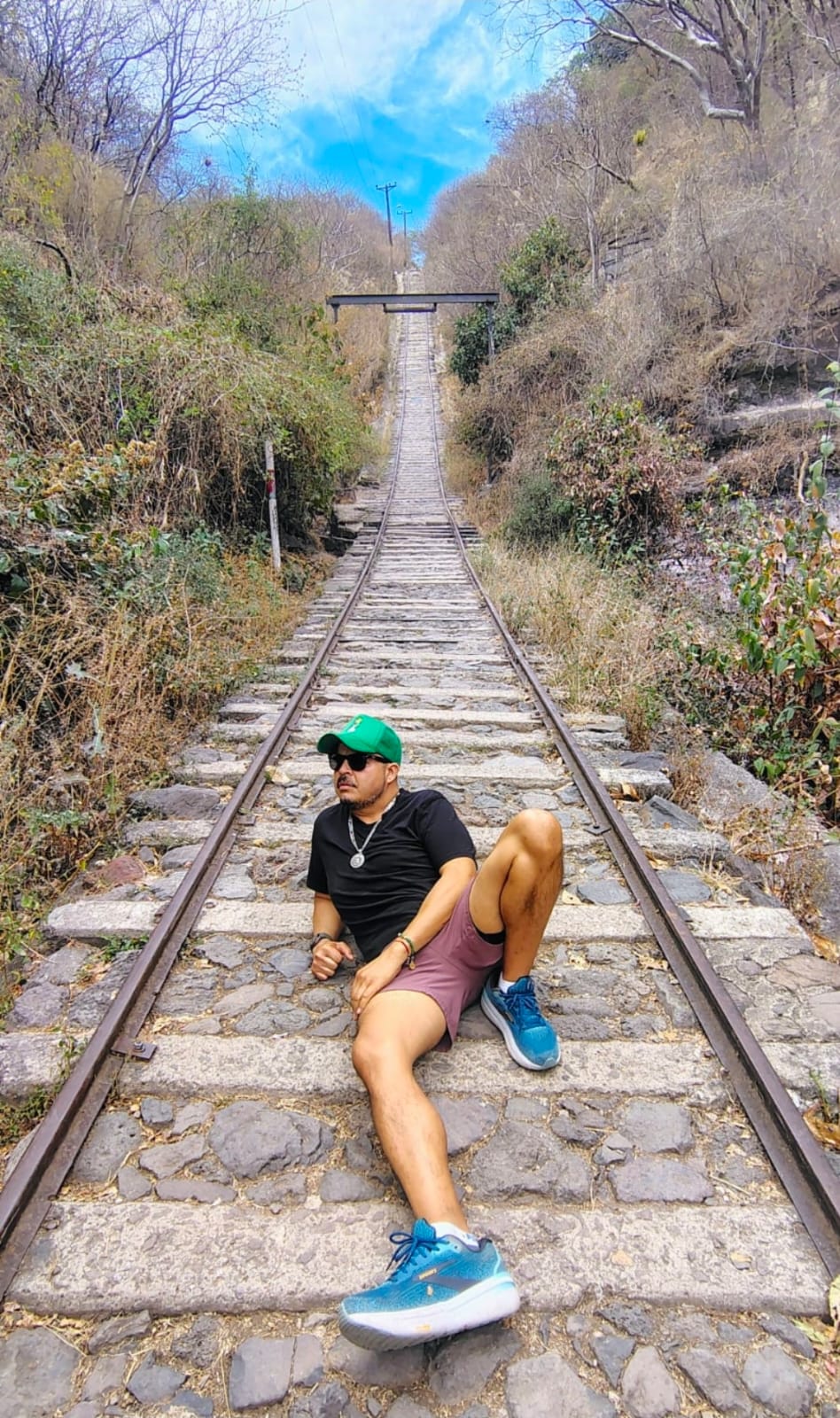 The founder today on railroad tracks wearing a green cap