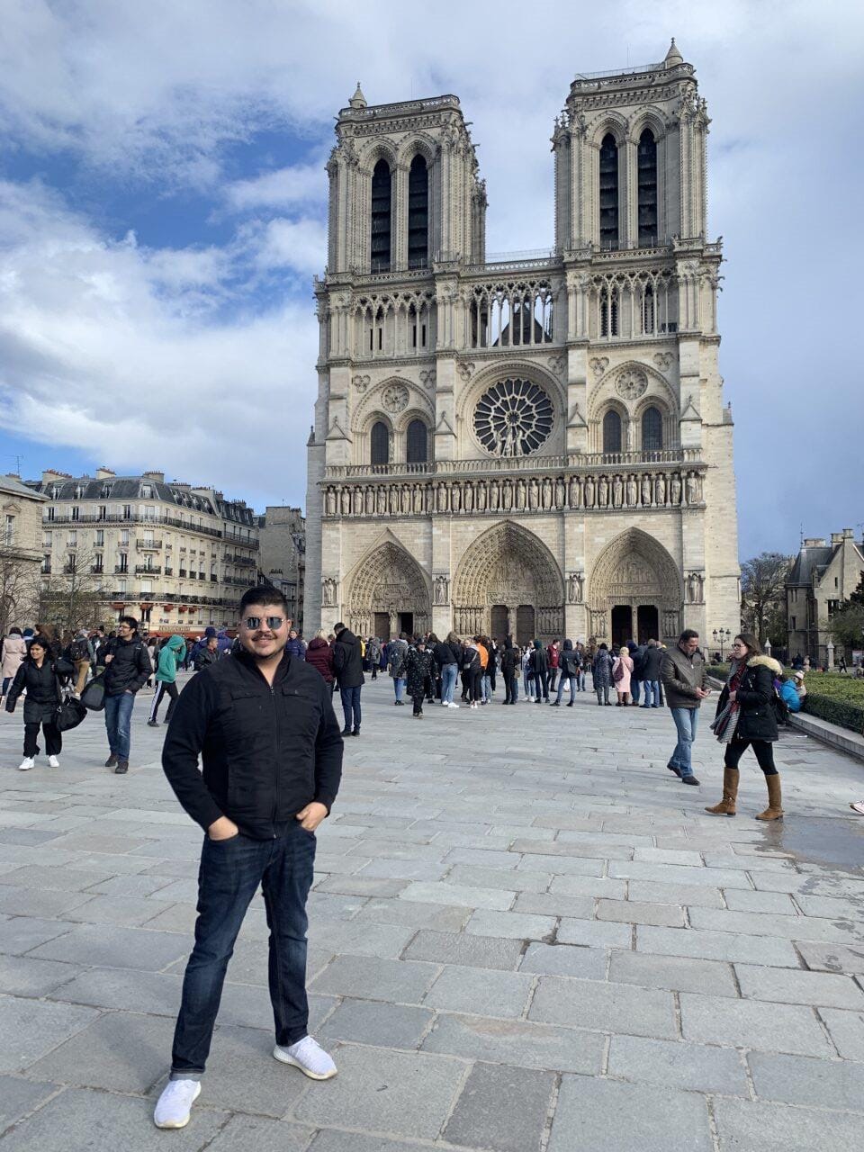 The founder traveling abroad, standing in front of Notre-Dame cathedral in Paris